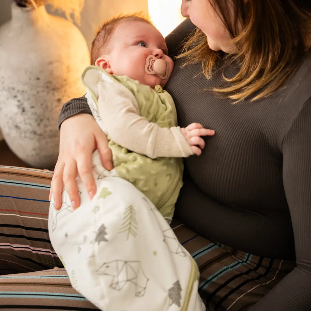 Baby iført tyndesovepose fra LilleLumi – LumiSack – i armene på sin mor