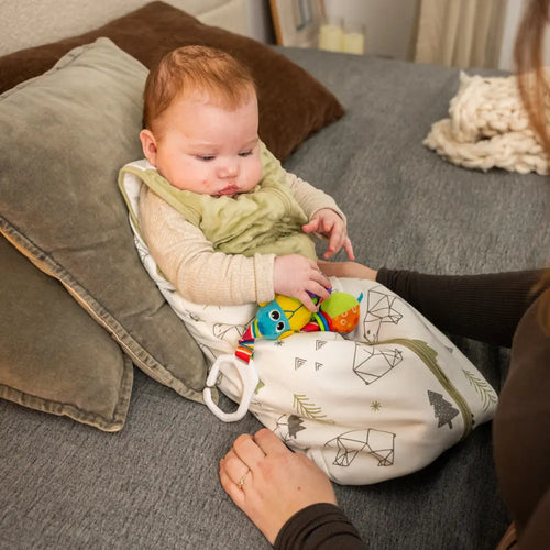 Baby leger med legetøj iført LumiSack tyndesovepose fra LilleLumi