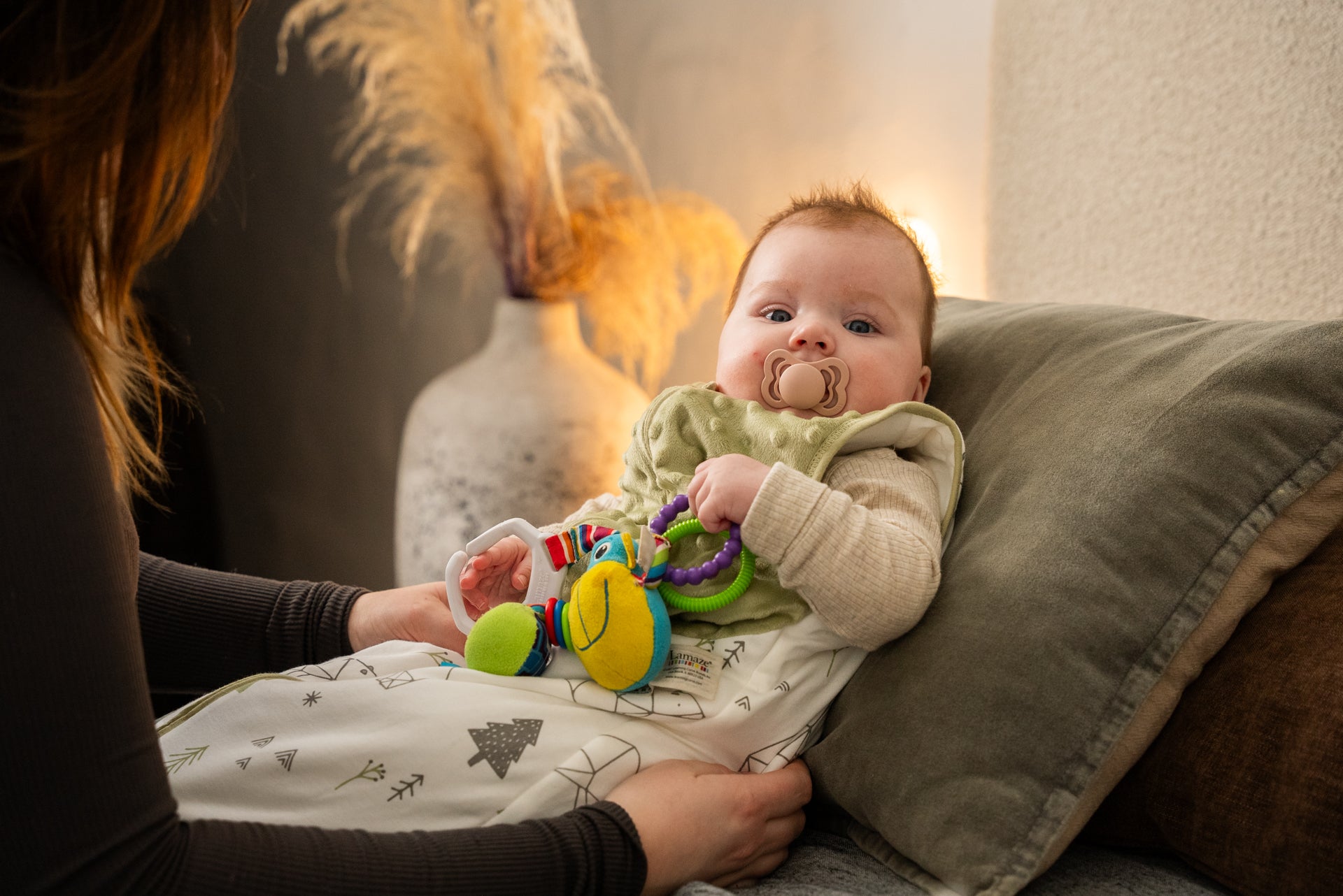 Baby i LumiSack tyngdesovepose fra LilleLumi leger og slapper af i sofaen